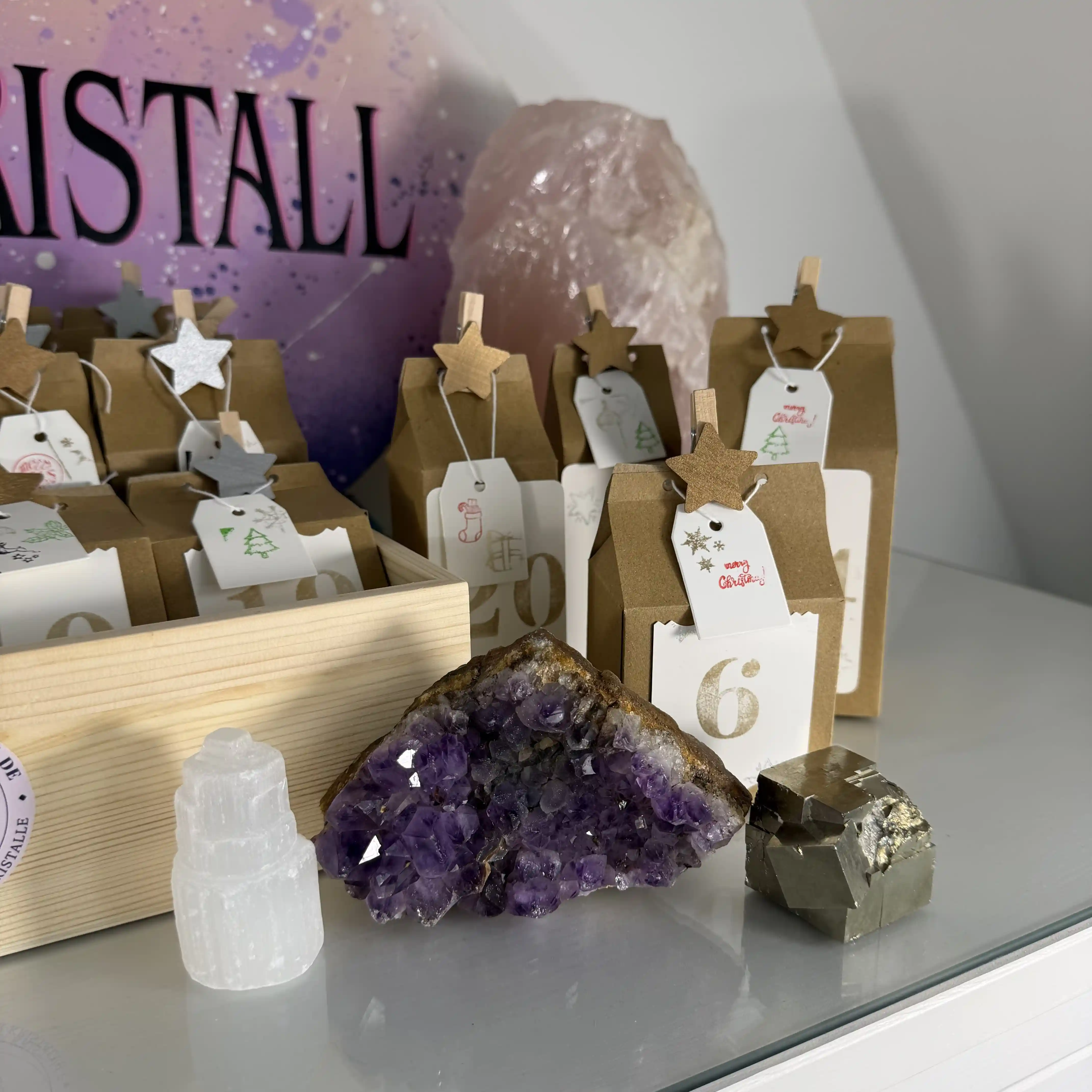 Geöffnete Türchen des Edelstein Adventskalenders 2026 mit Amethyst-Druse, Selenit und Pyrit
